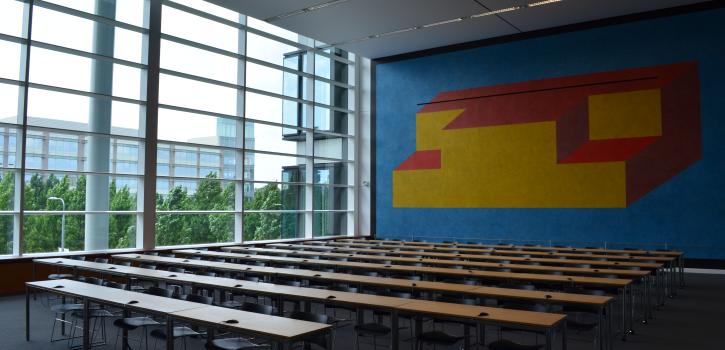 View of classroom tables, colorful mural and window wall