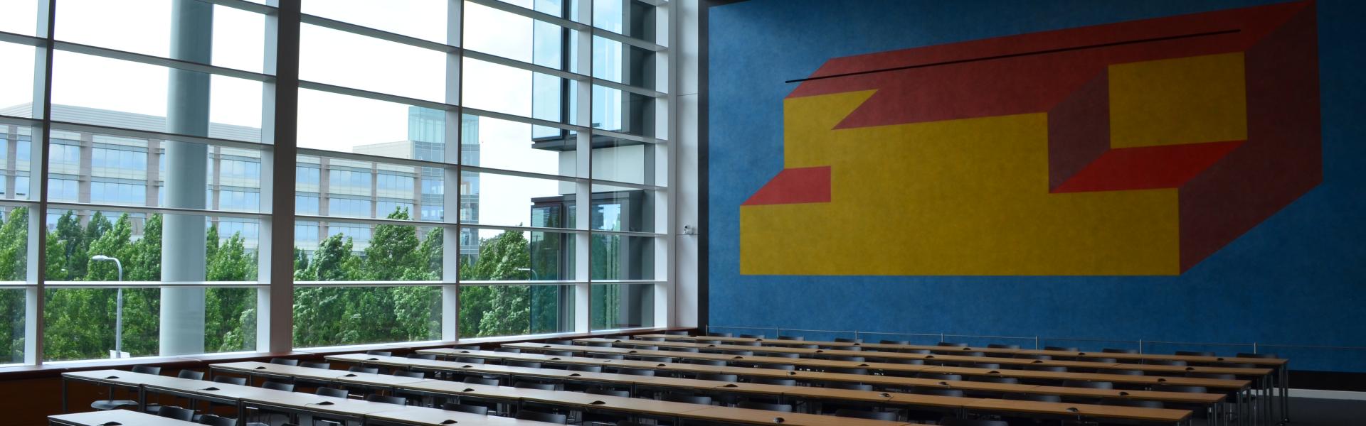 View of classroom tables, colorful mural and window wall